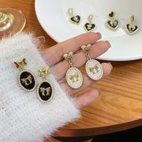 1 Pair Sweet Bow Knot Imitation Pearl Alloy Spray Paint Plating Women's Drop Earrings main image 3