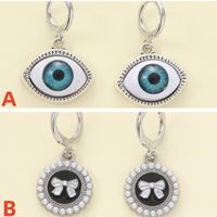 1 Paar Lässig Einfacher Stil Teufels Auge Bogenknoten Asymmetrisch Zinklegierung Künstliche Perlen Tropfenohrringe main image 1