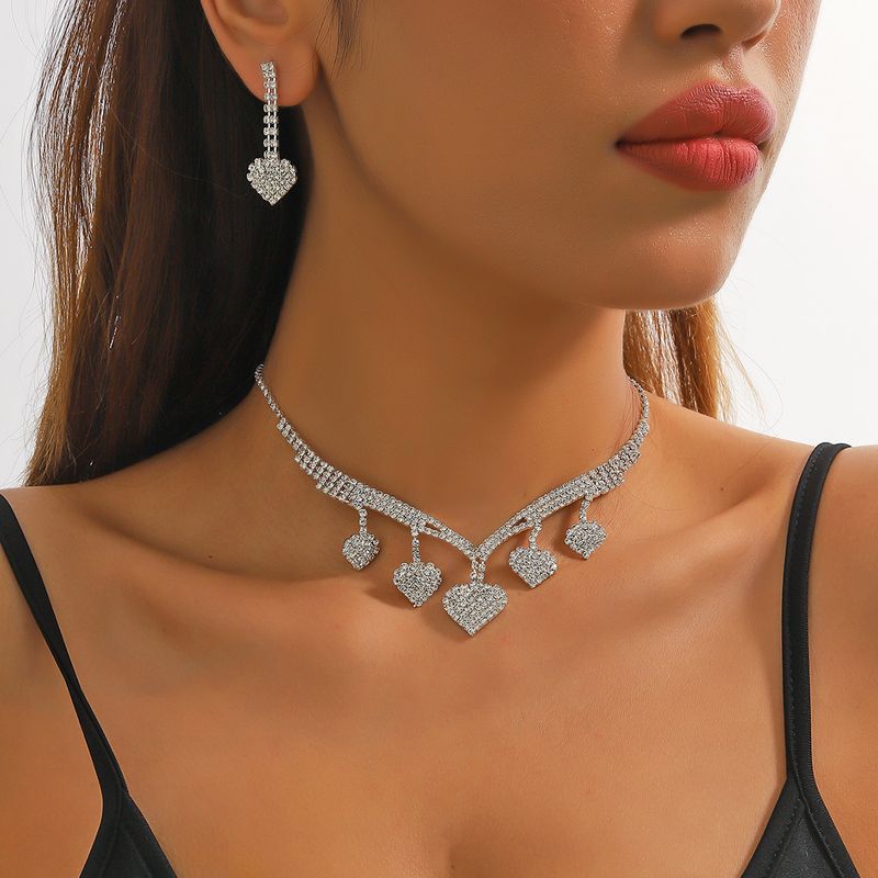 Elegante Ropa De Calle Forma De Corazón Aleación Embutido Diamantes De Imitación Plateado Mujeres Aretes Collar