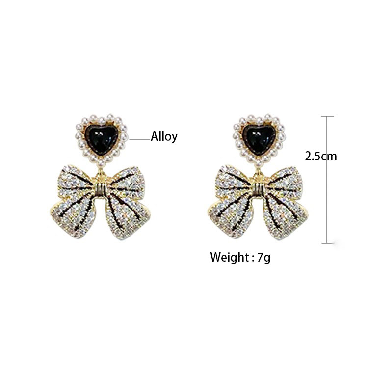 Fashion Retro Pearl Inlaid Heart Bow Shape Pendant Women's Earrings display picture 1